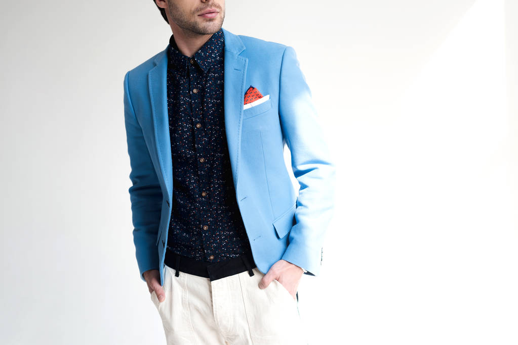 bijgesneden shot van de jongeman in stijlvolle blauwe jas op wit - Foto, afbeelding