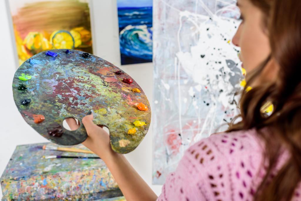 Palet boya ile atölyede tutan güzel kadın sanatçı - Fotoğraf, Görsel