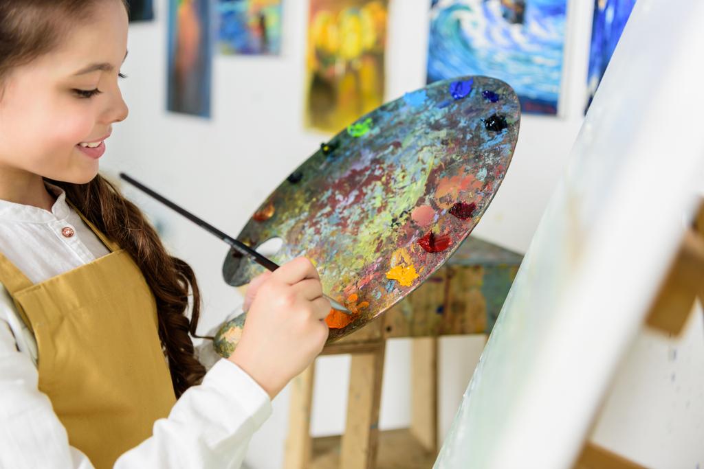 bambino che prende la vernice da tavolozza in workshop di scuola artistica
 - Foto, immagini