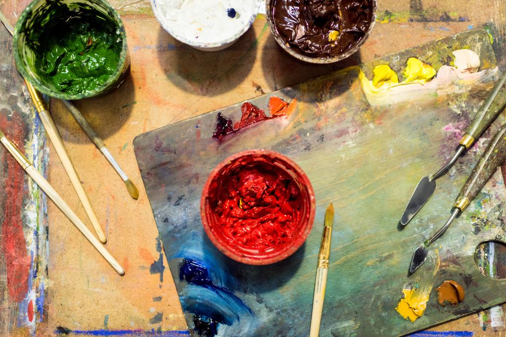 το Top view ζωγραφική βούρτσες, παλέτα και χρώματα αφίσα στο ξύλινο τραπέζι στο εργαστήριο - Φωτογραφία, εικόνα