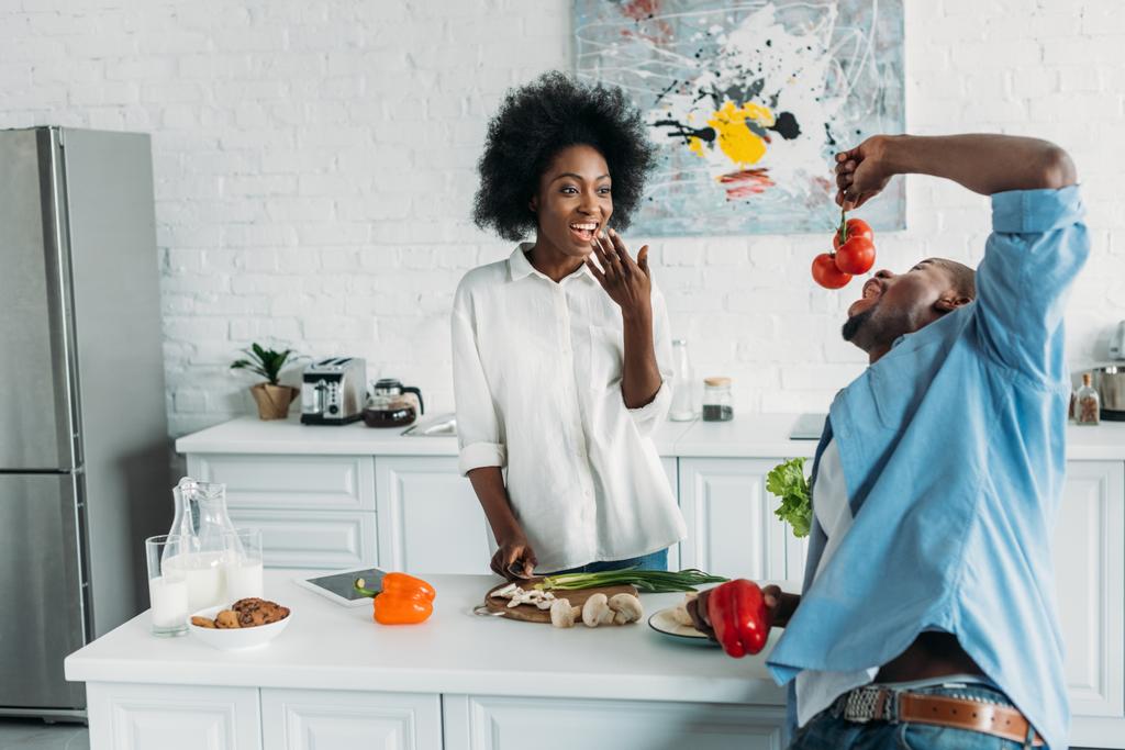 coppia afro-americana con verdure fresche in tavola al mattino a casa
 - Foto, immagini