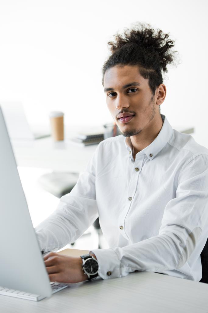 νεαρός επιχειρηματίας αφρικανικές αμερικανικές λειτουργεί με επιτραπέζιο υπολογιστή και βλέπουν τα φωτογραφικών μηχανών - Φωτογραφία, εικόνα