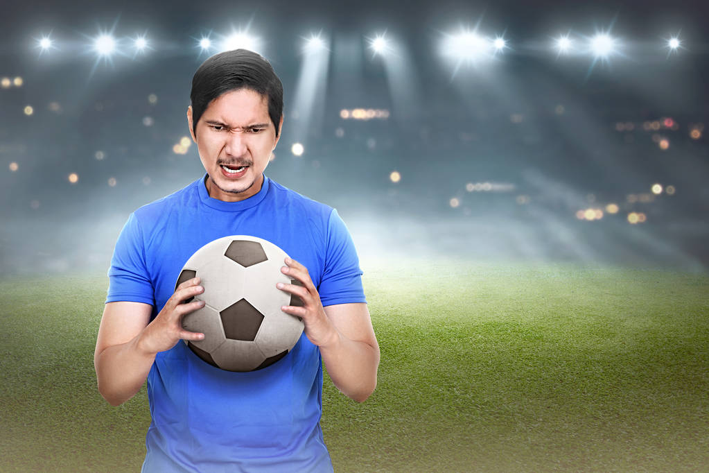asiático fútbol jugador con pelota en las manos
 - Foto, imagen