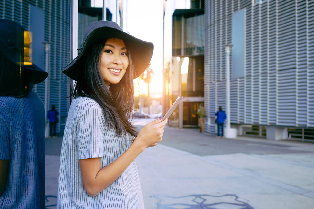 Giovane donna d'affari asiatica elegante utilizzando tablet digitale vicino ai grattacieli
 - Foto, immagini