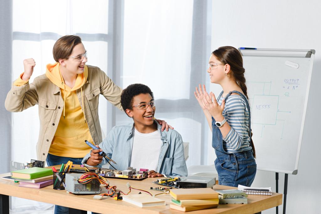 heureux multiculturels adolescents montrant oui geste tandis que l'ingénierie à la maison
 - Photo, image