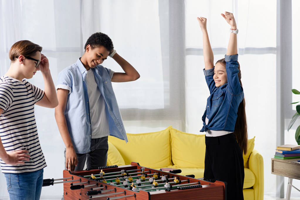 happy teen kid winning table football at multicultural teenagers at home - Photo, Image