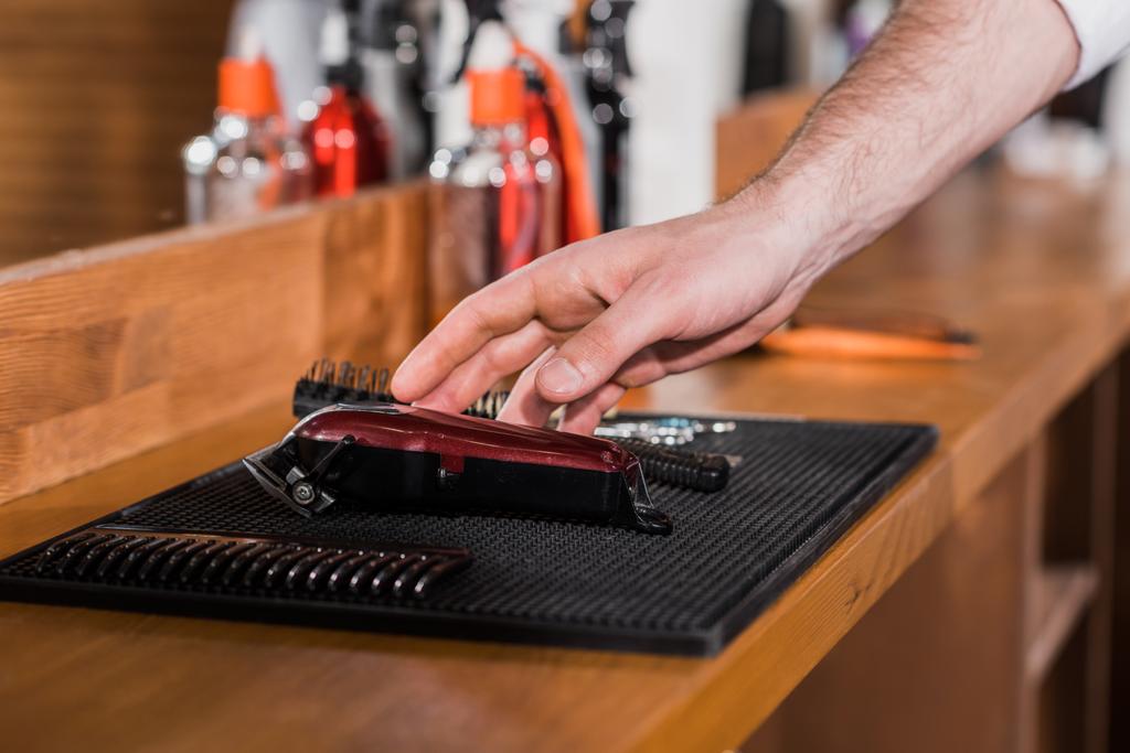 cropped shot of barber choosing tools from rubber mat at workplace - Photo, Image
