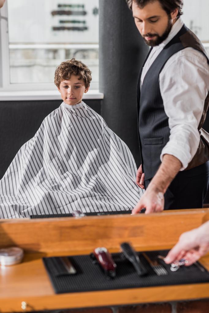 κατοπτρική ανάκλαση του κουρέα, ετοιμάζονται να κόψουν τα μαλλιά από μικρό παιδί - Φωτογραφία, εικόνα