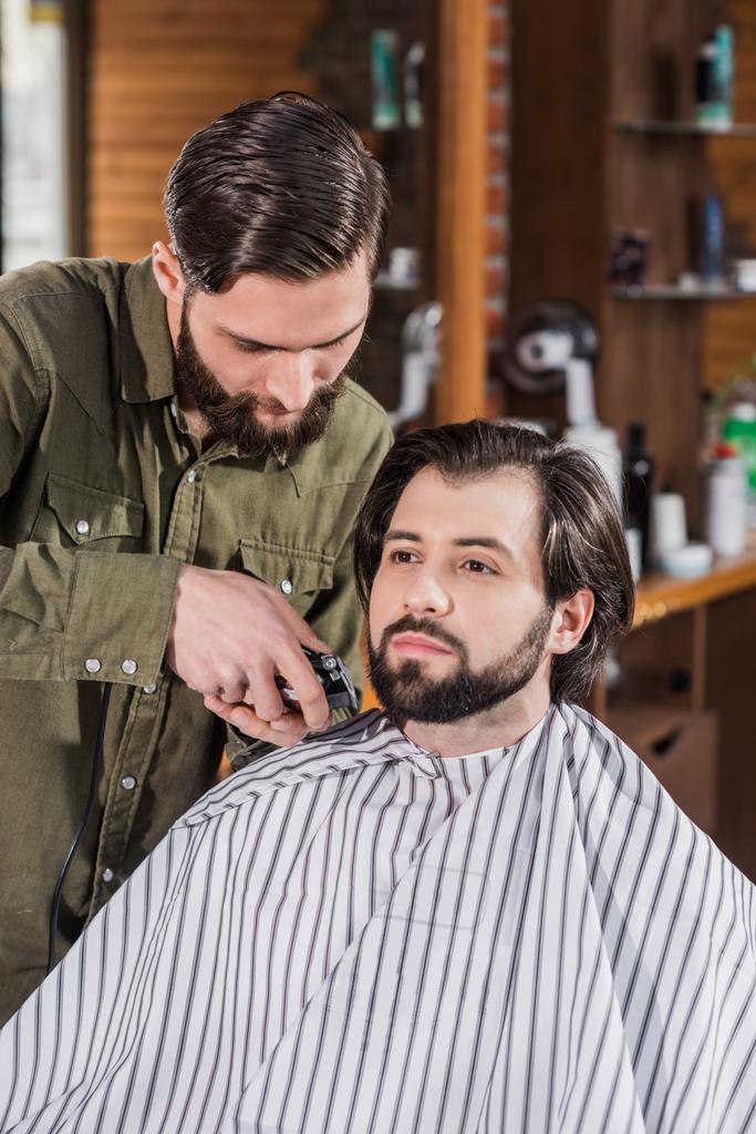 Kapper scheren client met Hair Clipper op barbershop - Foto, afbeelding