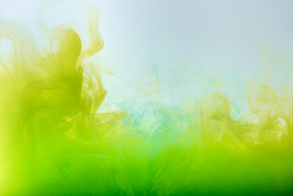 abstract background with flowing yellow and green gouache paint in water - Photo, Image