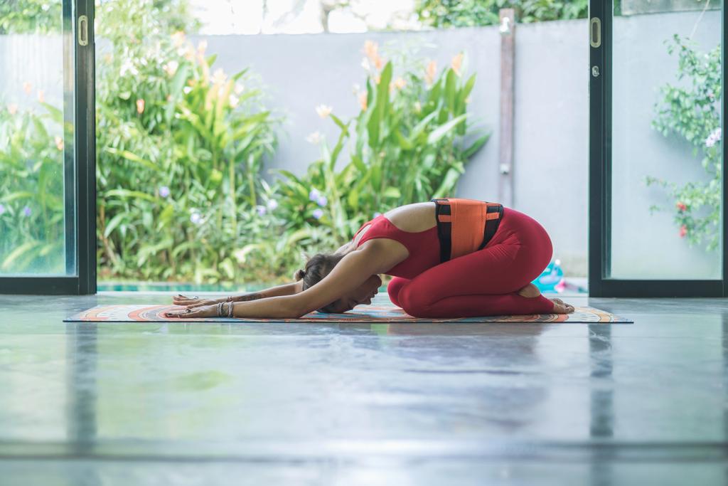 vista lateral de la joven practicando yoga en pose de niño extendido (Utthita Balasana)
 - Foto, Imagen