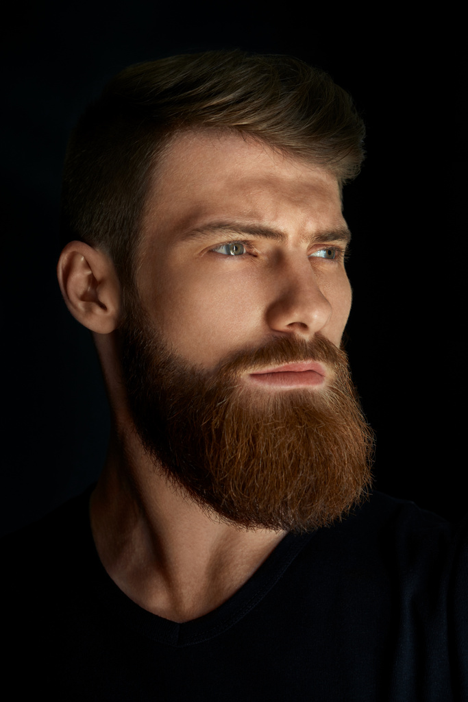 Портрет молодого красивого бородатого человека, который смотрит вперед
 - Фото, изображение