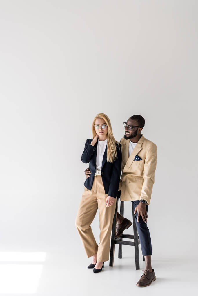 beau jeune couple multiethnique à la mode en lunettes posant ensemble sur gris
 - Photo, image