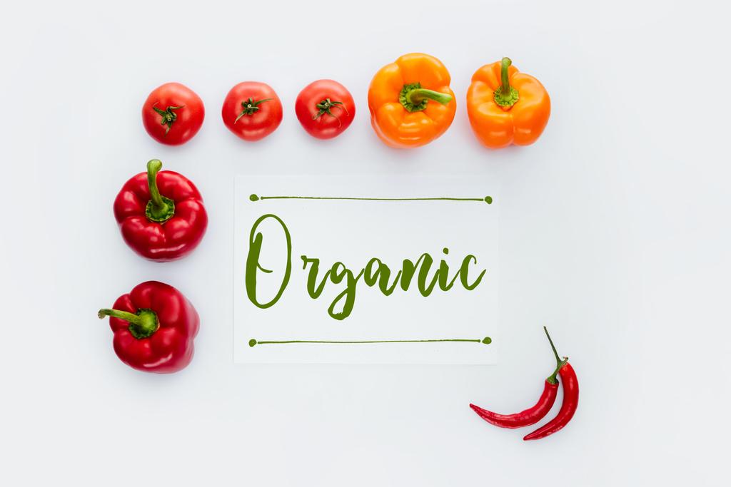 Widok z góry ramki czerwone i pomarańczowe warzywa z word na białym tle organiczny - Zdjęcie, obraz