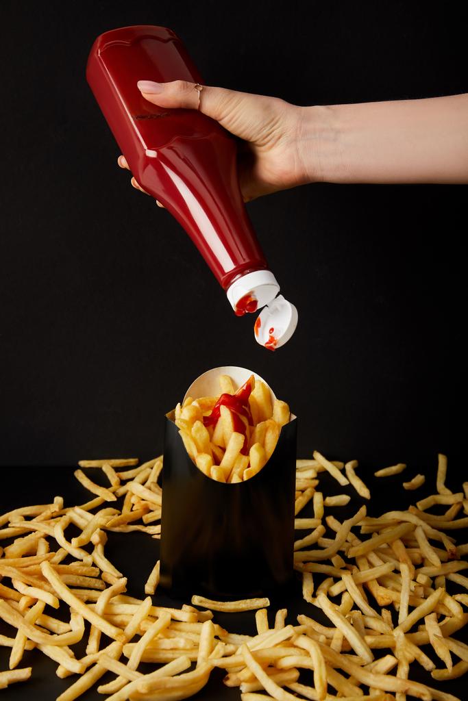 Schnappschuss einer Frau, die Ketchup auf Pommes frites gießt - Foto, Bild