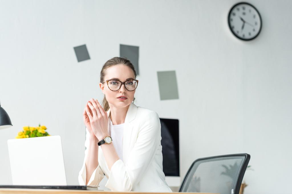retrato de mujer de negocios en traje blanco y anteojos en el lugar de trabajo con computadora portátil en la oficina
 - Foto, imagen