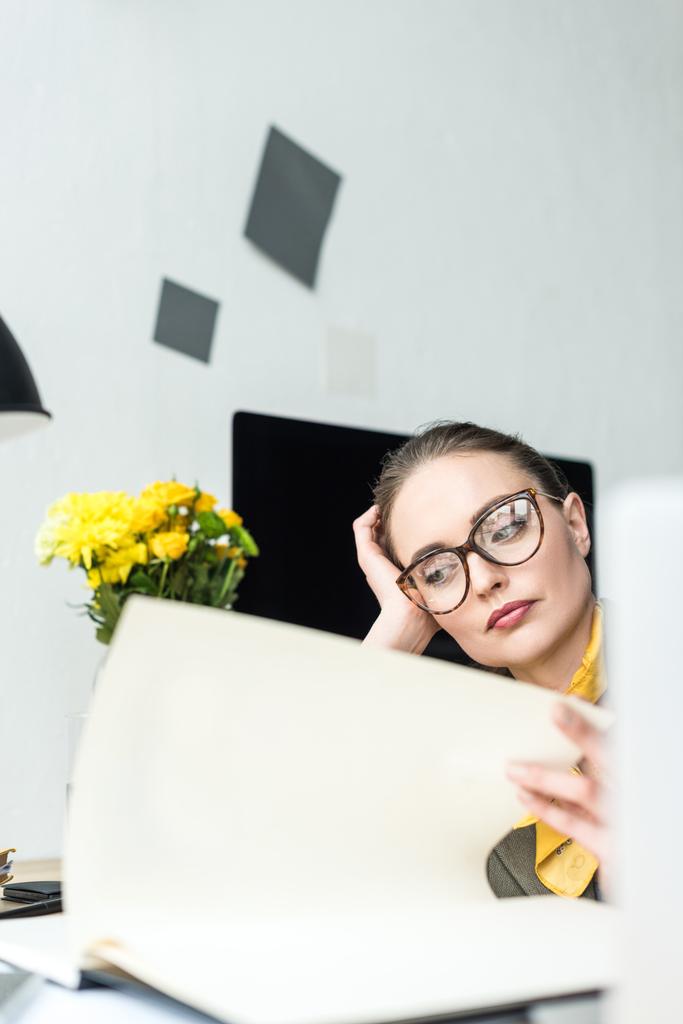 visione ravvicinata della donna d'affari annoiata negli occhiali che lavora con documenti sul posto di lavoro
 - Foto, immagini