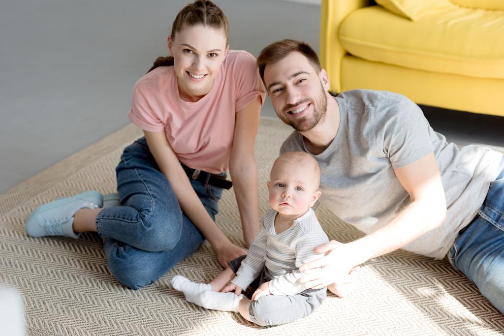 glückliche Familie mit Baby auf dem Boden sitzend - Foto, Bild