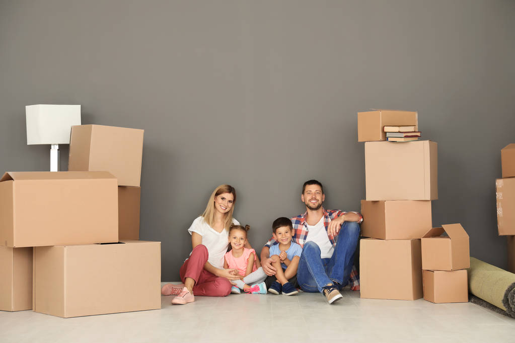 Família feliz com caixas de papelão em novo apartamento
 - Foto, Imagem