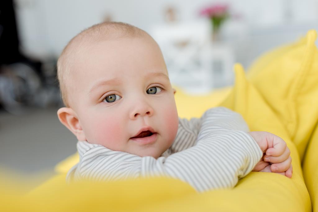 imádnivaló baba kisfiú látszó-on fényképezőgép, sárga kanapén - Fotó, kép