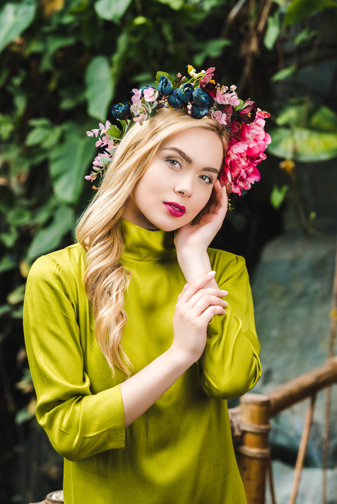 krásná mladá žena s květinovým věncem při pohledu na fotoaparát - Fotografie, Obrázek