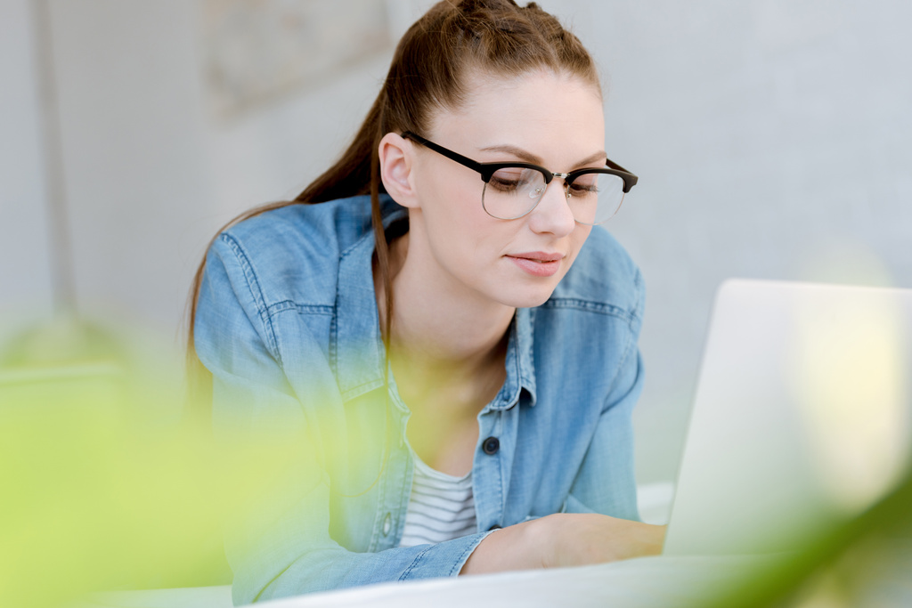 Atrakcyjna młoda kobieta w okularach za pomocą laptopa   - Zdjęcie, obraz
