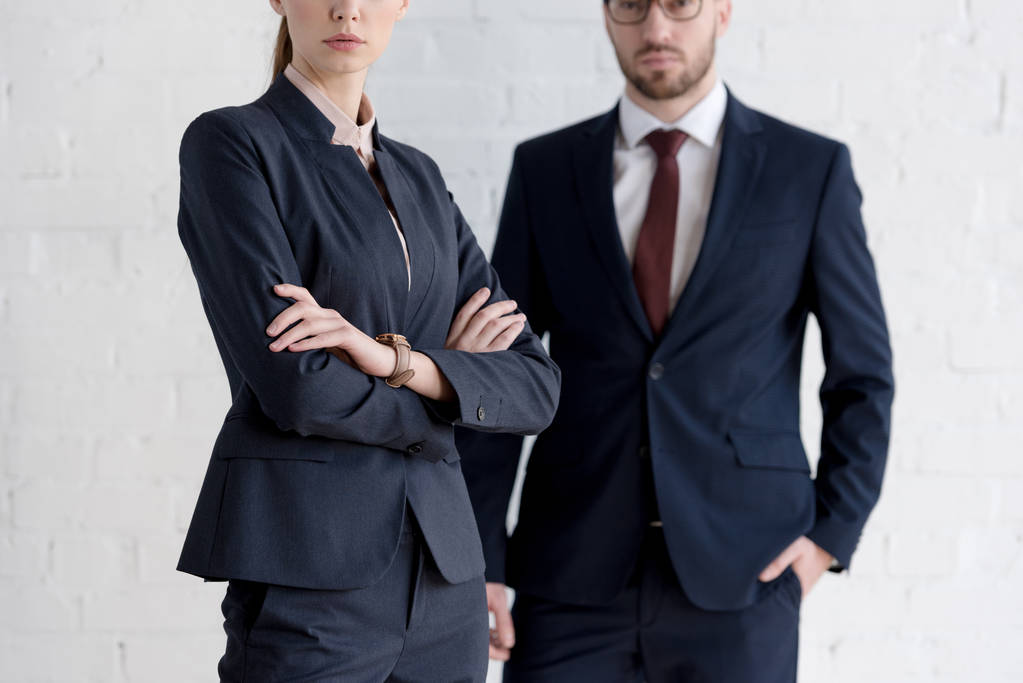 cropped view of businessman and businesswoman with crossed arms posing near white wall - Photo, Image