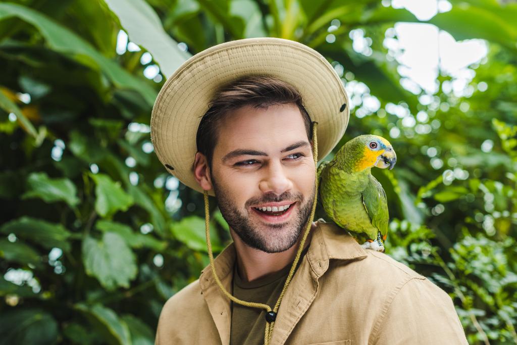 schöner junger Mann mit Papagei auf der Schulter - Foto, Bild