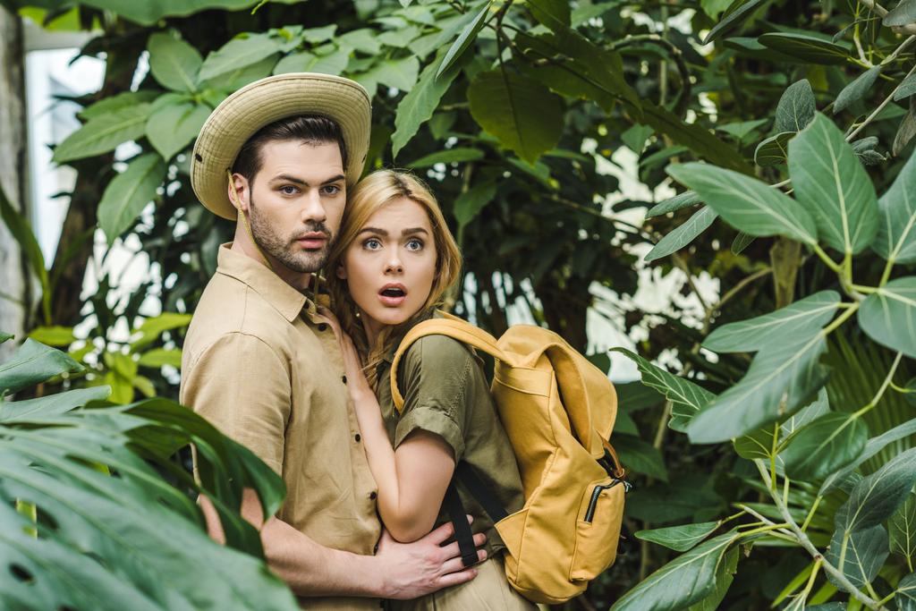 испуганная молодая пара в сафари-костюмах в джунглях
 - Фото, изображение