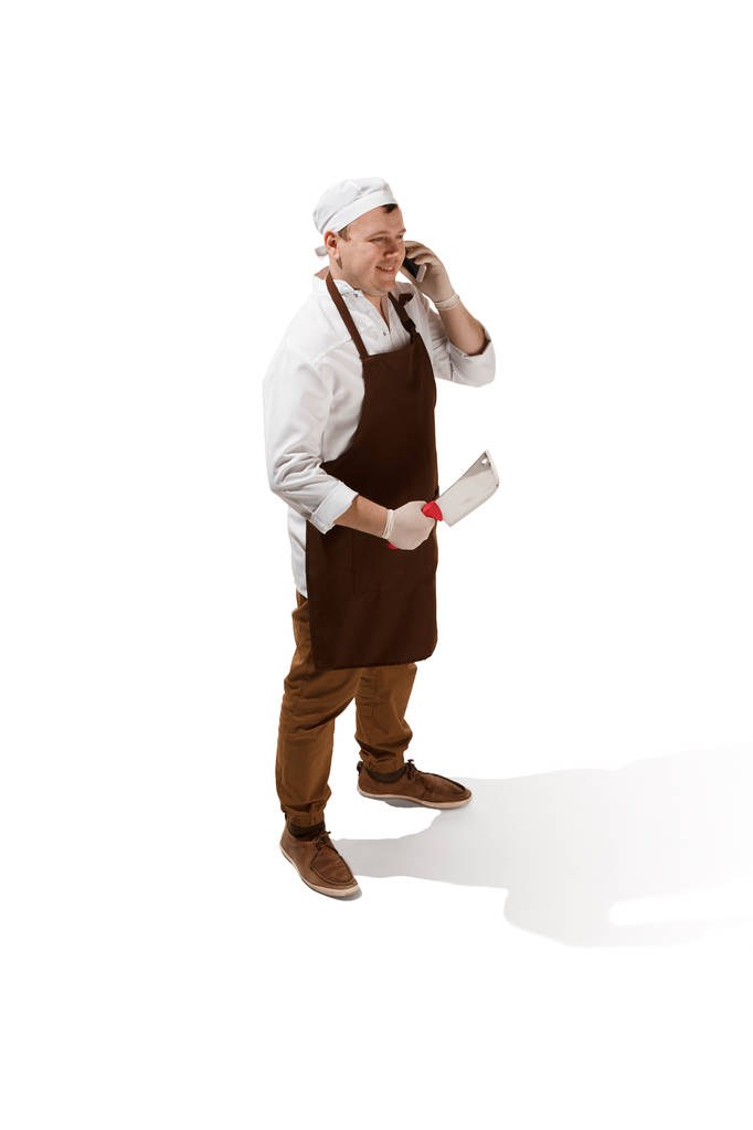 Carnicero sonriente posando con una cuchilla aislada sobre fondo blanco
 - Foto, Imagen