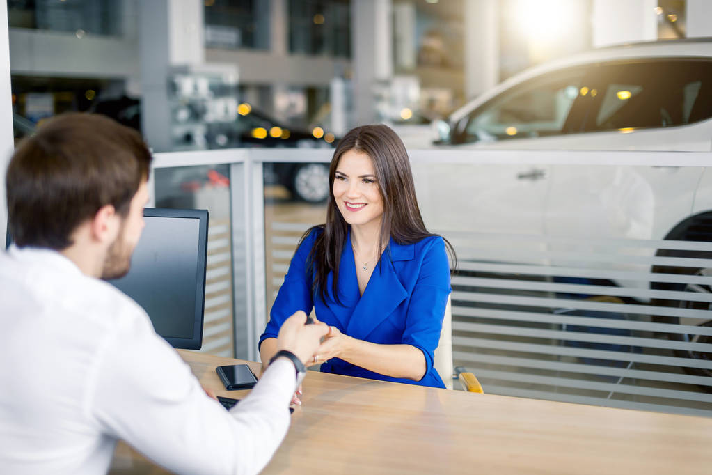 Attractive european woman receiving car keys from car sales agent - Photo, Image