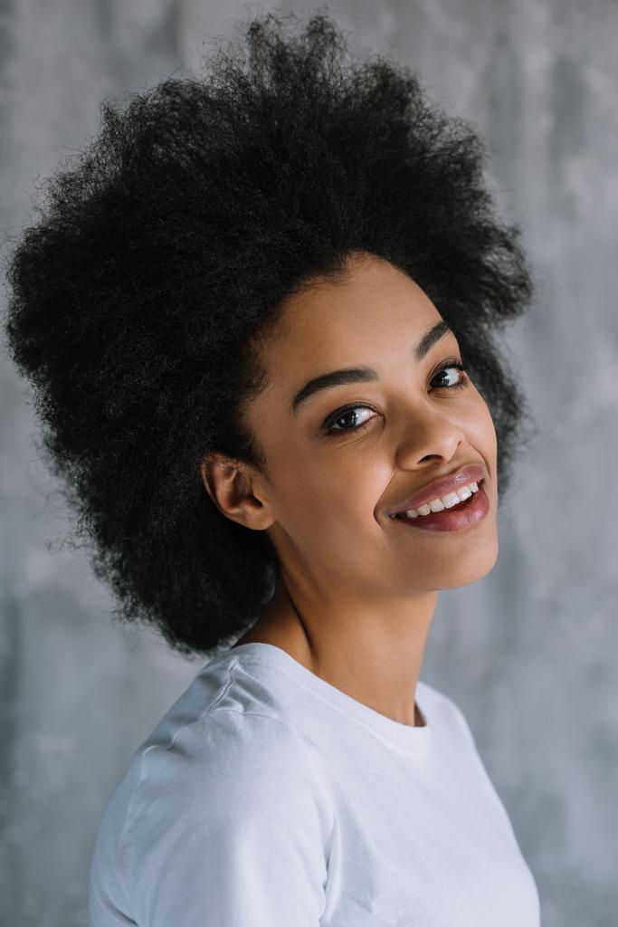 Hymyilevä melko afrikkalainen amerikkalainen tyttö harmaa seinä tausta
 - Valokuva, kuva