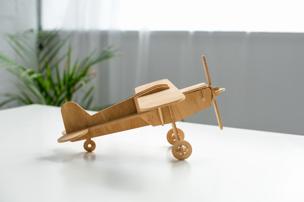 白いテーブルの上の木製のおもちゃの飛行機ビューをクローズ アップ - 写真・画像