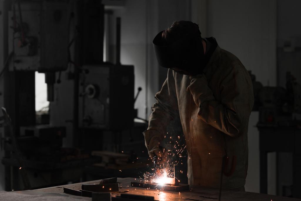 vista frontal del trabajador en metal de soldadura máscara de protección en fábrica
  - Foto, Imagen