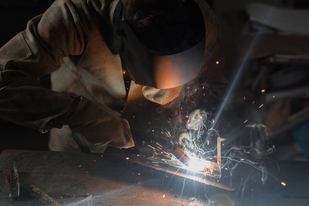 manufacture worker welding metal with sparks at factory  - Photo, Image