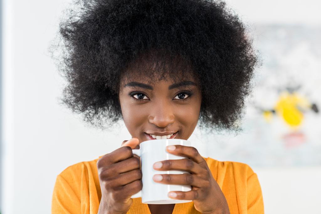 retrato de mulher africana americana sorridente com xícara de café em casa
 - Foto, Imagem