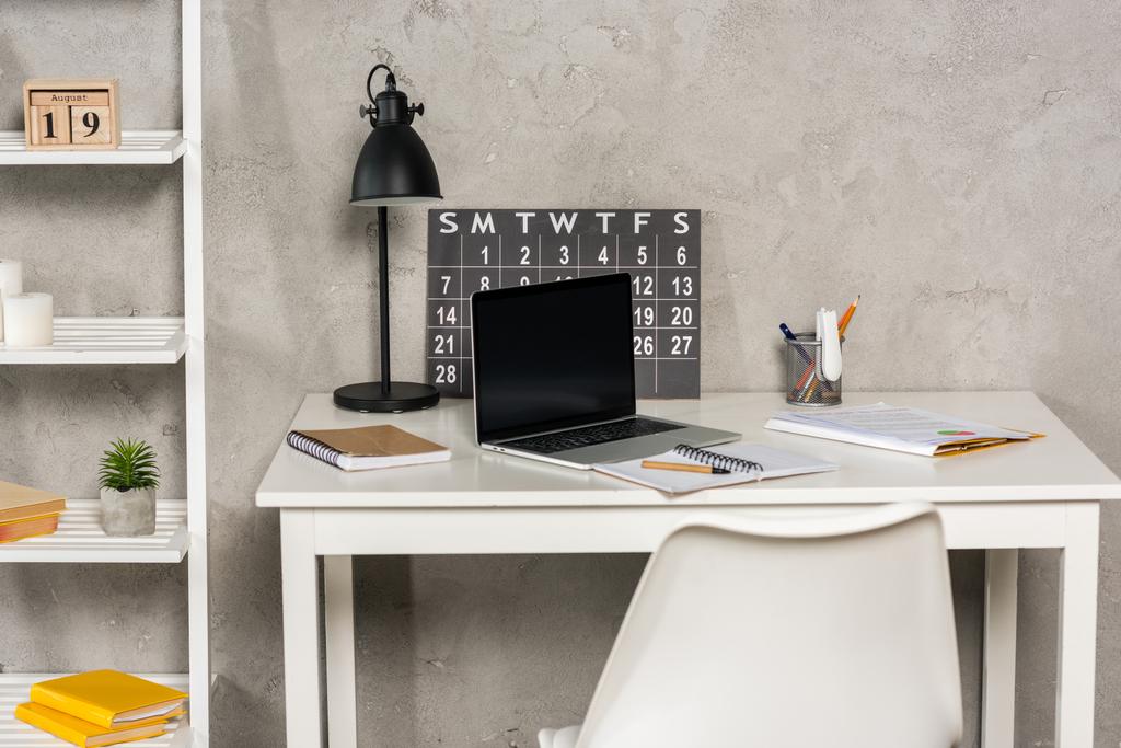 vue rapprochée de l'ordinateur portable avec écran vierge, papiers, calendrier et cahiers sur le lieu de travail au bureau à domicile
 - Photo, image