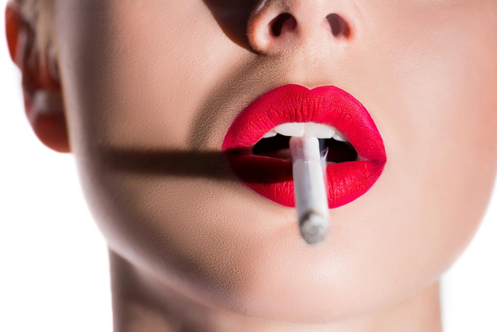 bijgesneden afbeelding van vrouw met sigaret met rode lippen geïsoleerd op wit - Foto, afbeelding