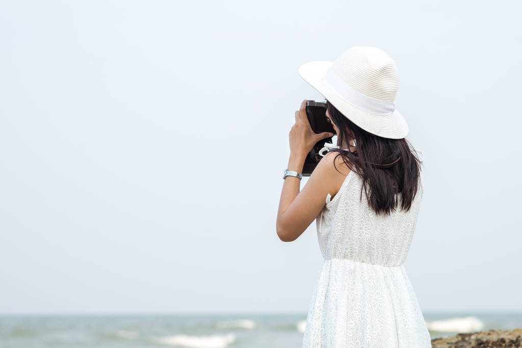 Mujer turista asiática tomando fotos en la playa
. - Foto, Imagen