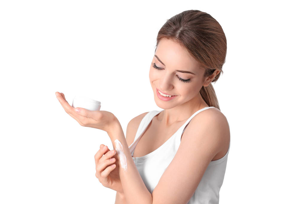 Mladá žena použitím krém na ruce na bílém pozadí - Fotografie, Obrázek