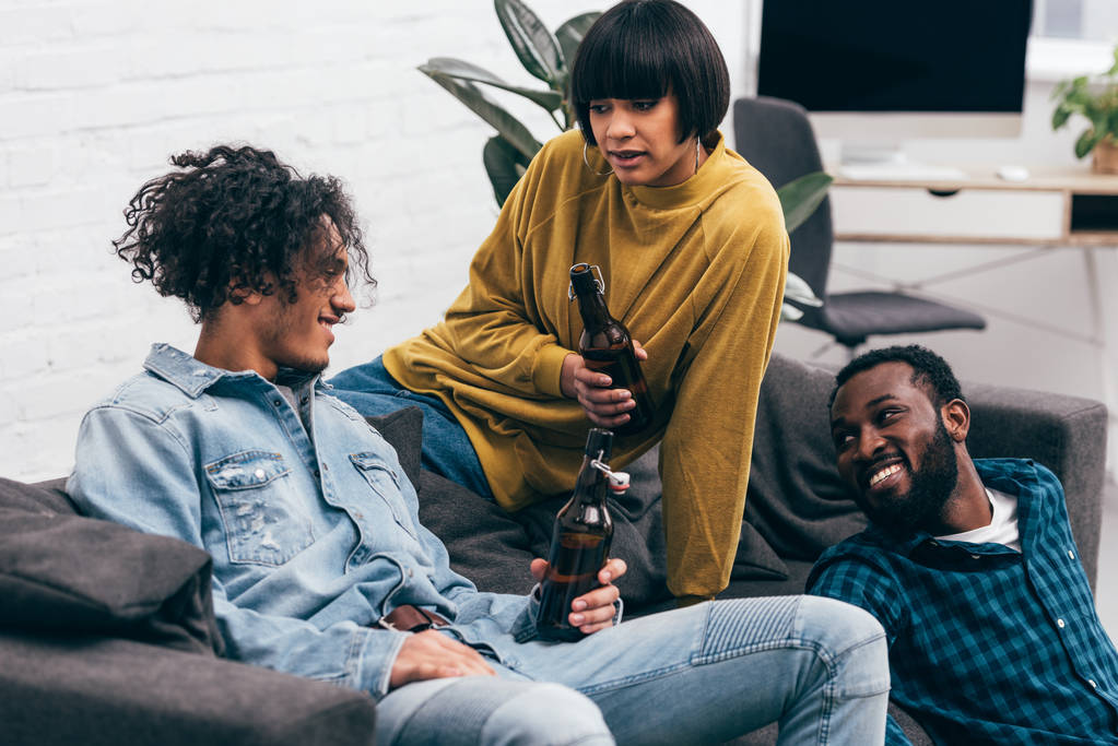 grupo de jóvenes amigos multiculturales con botellas de cerveza hablando entre sí
 - Foto, imagen