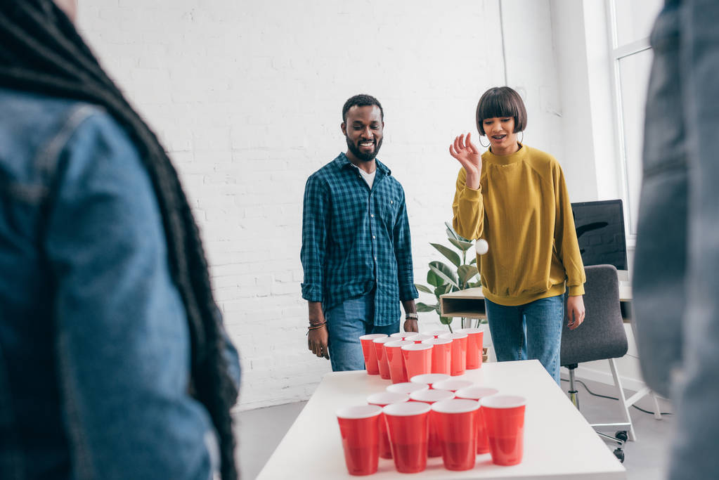 plan recadré d'un groupe multiethnique d'amis jouant au bière pong à table
  - Photo, image