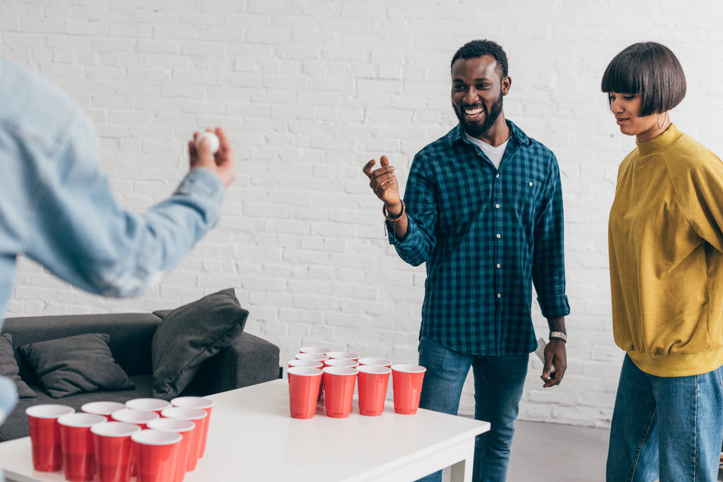 imagen recortada de grupo multiétnico de amigos jugando al pong de cerveza en la mesa
  - Foto, imagen