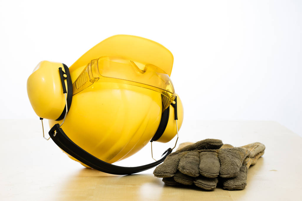 Protective helmet and work boots on a wooden table. Safety and h - Photo, Image