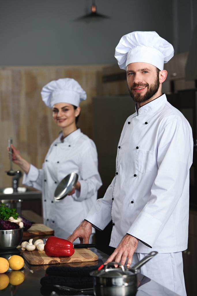 Επαγγελματίες σεφ άνδρας και η γυναίκα το μαγείρεμα στην κουζίνα εστιατορίου - Φωτογραφία, εικόνα