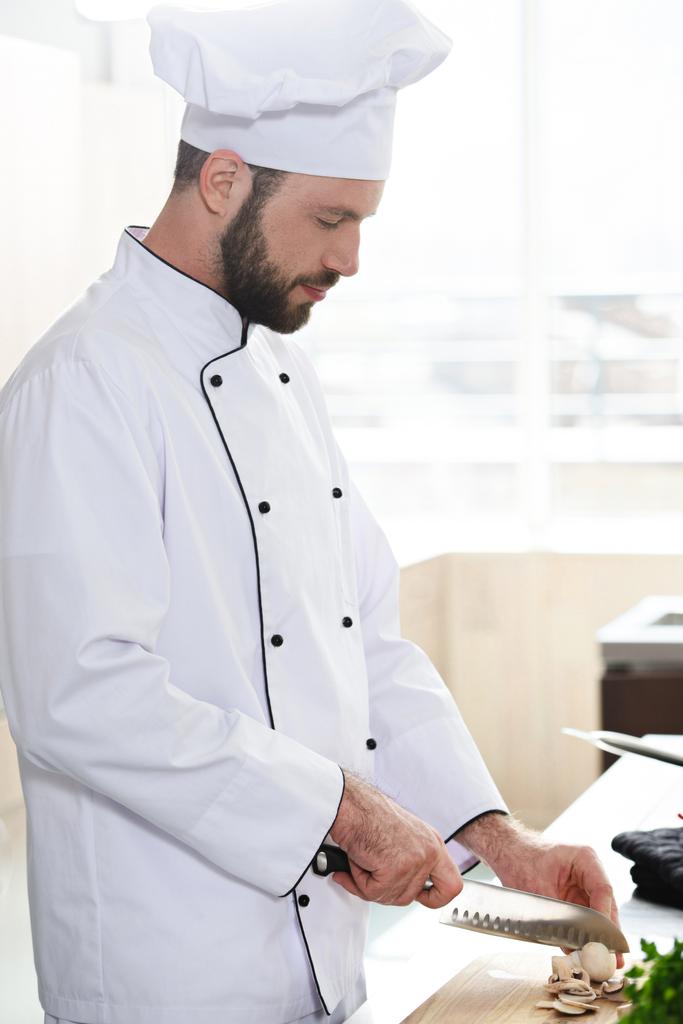 Професійний шеф-кухар, який ріже гриби на кухонному столі
 - Фото, зображення