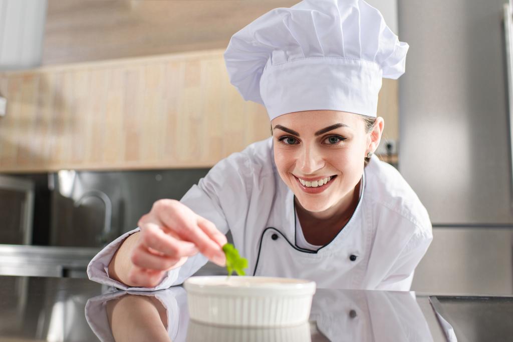 Piatto di guarnitura chef femminile sulla cucina ristorante
 - Foto, immagini