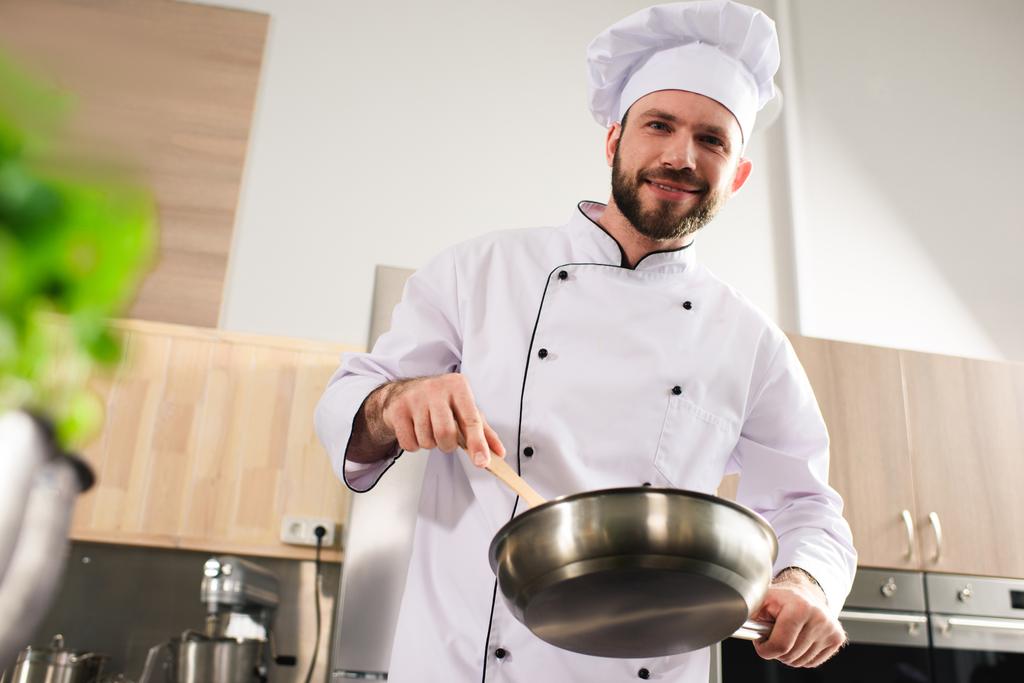 Kucharz mężczyzna trzymając patelnię na nowoczesną kuchnię - Zdjęcie, obraz