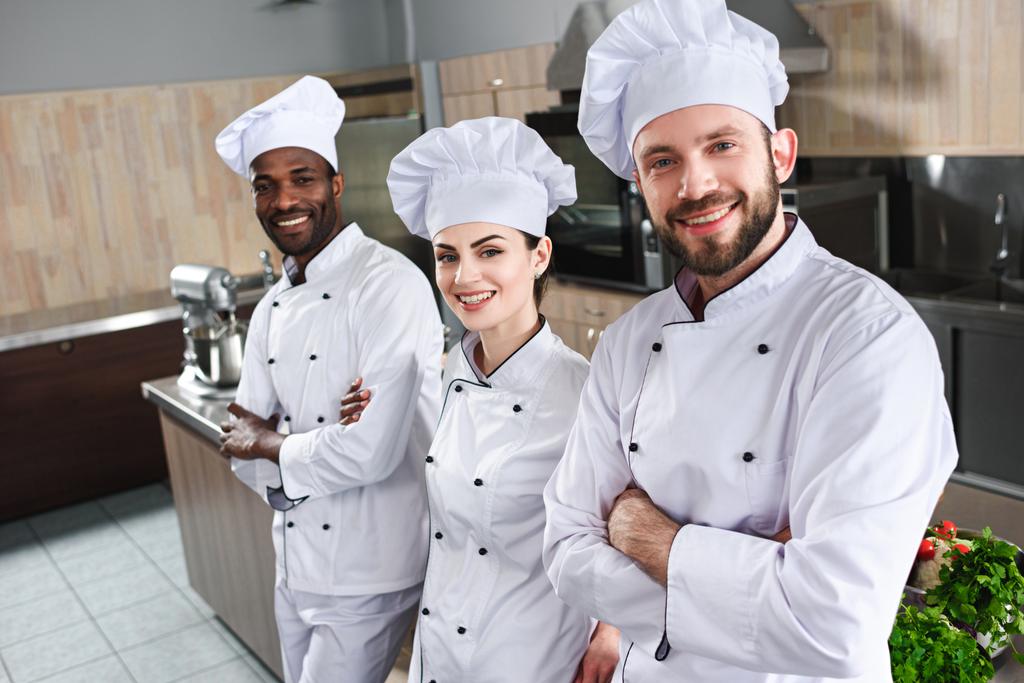 Tablo pişirme tarafından kameraya bakarak aşçıların çok ırklı takım - Fotoğraf, Görsel