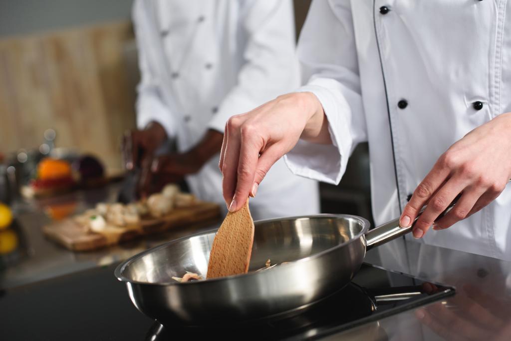 Крупный план приготовления пищи женского повара на сковороде
 - Фото, изображение